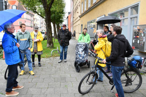 Hans-Otto Kraus (links, ehem. Geschäftsführer der GWG) mit TeilnehmerInnen (u.a. die Fraktionssprecherin Nina Reitz, rechts in gelb) am Kreuzplätzchen in der unteren Au (© Peter Martl)