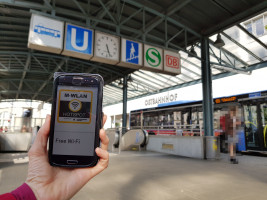Smartphone zeigt M-Net-WLAN-App an der Bushaltestelle Ostbahnhof