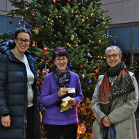 Dr. Lena Sterzer, stv. Bezirksausschussvorsitzende; Silvia Arto (Sozialbürgerhaus); Nina Reitz (Bezirksausschuss 5) vor dem geschmückten Weihnachtsbaum des Sozialbürgerhauses am Ostbahnhof